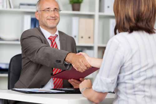 Two adults shake hands over a Fiduciary agreement